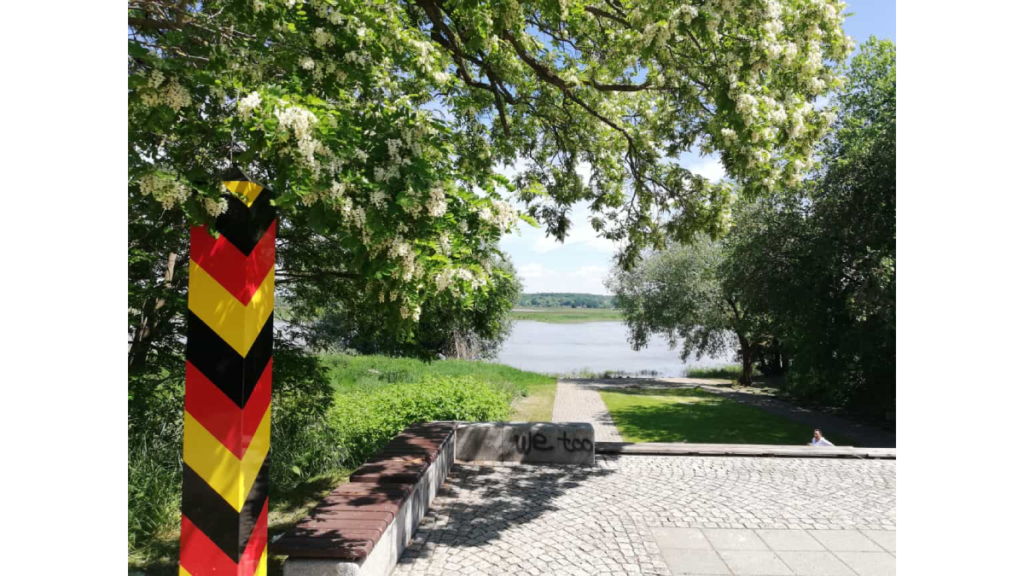 Ein Grenzpfosten in schwarz-rot-gold an der Oder. Blick von der Insel Ziegenwerder auf einen Seitenarm der Oder nach Polen