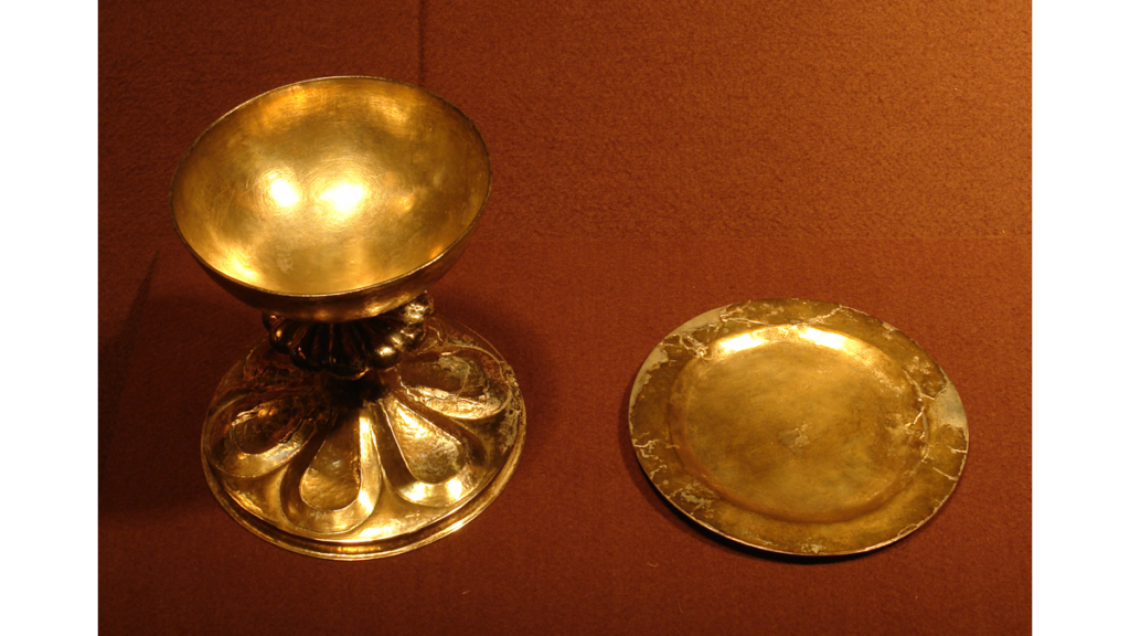 Ein goldener Kelch und eine goldene Patene in einer Museumsvitrine, die für das Abendmahl genutzt wurden