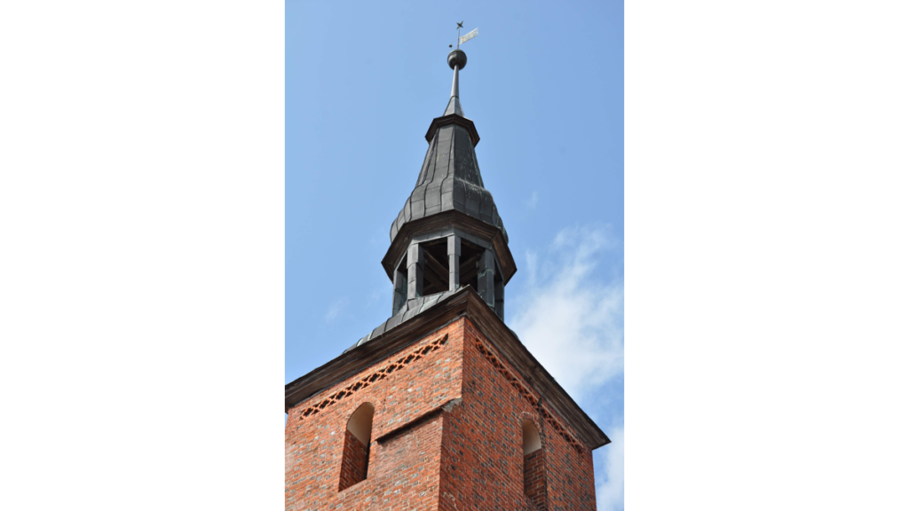 Ein Turm auf einem Kirchendach mit Wetterfahne