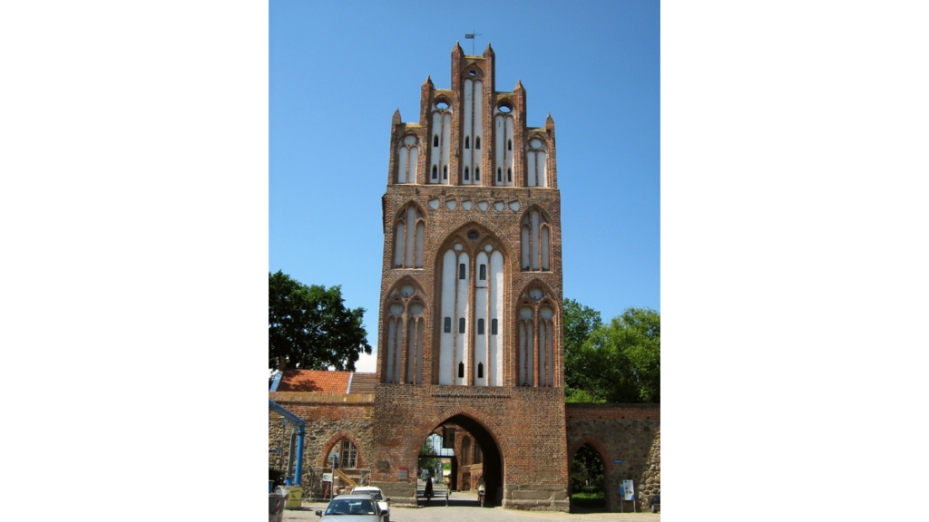 Ein aus dem Mittelalter stammendes Tor in der Stadtmauer mit einem treppenartig anmutenden Giebeldach, das Treptower Tor