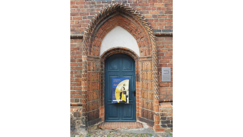 Eine blaue Tür ist das Hauptportal der Sankt Lazarus Kapelle- Ein Plakat hängt vor der Tür