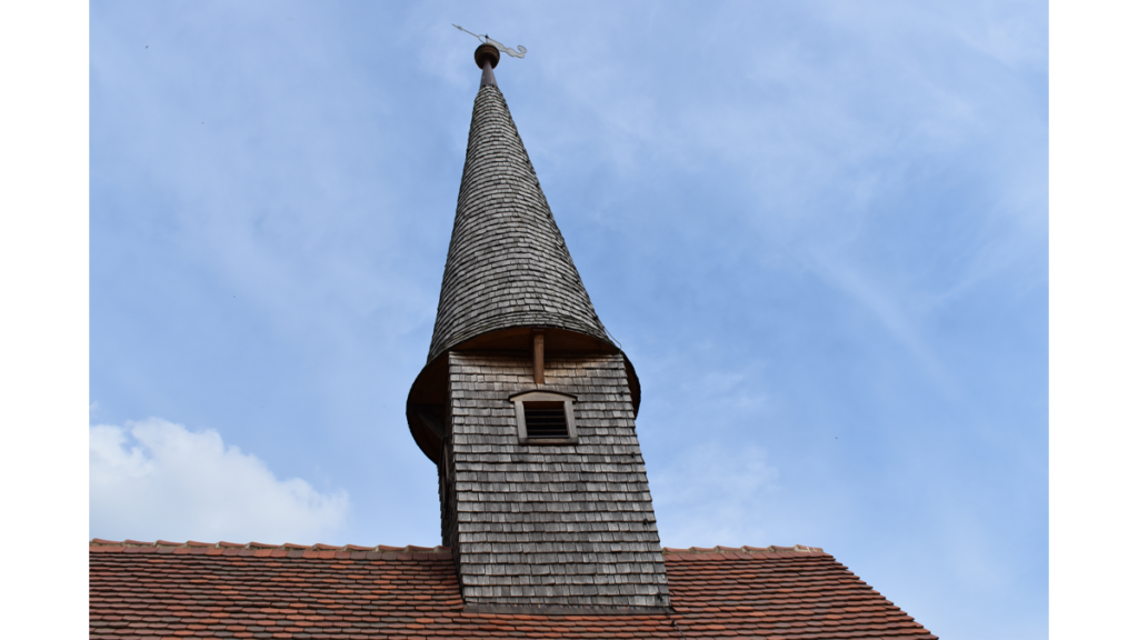 Ein spitzes Türmchen auf dem Dach der Sankt Georg Kapelle