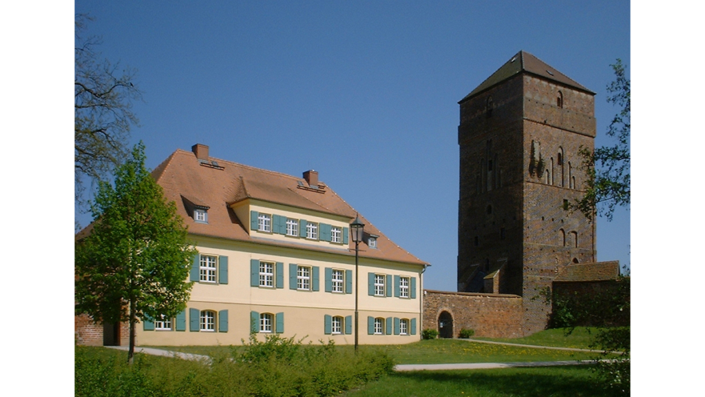 Ein Außenbild zeigt einen alten Bischofssitz mit Turm
