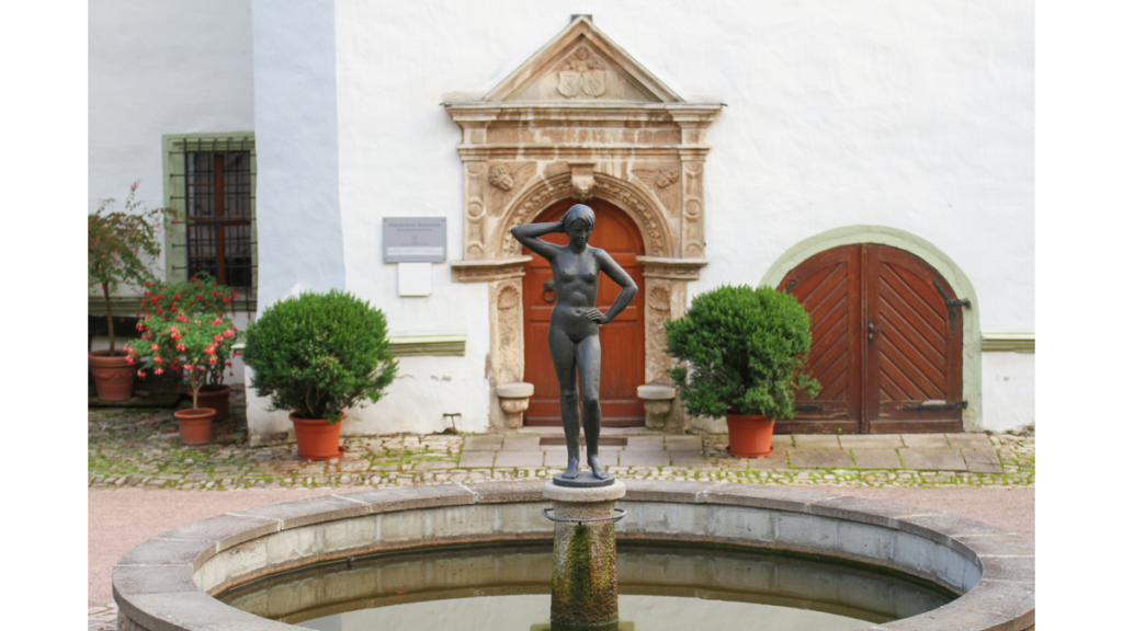 Eine Figur in einem Brunnen vor dem Renaissance Schloss