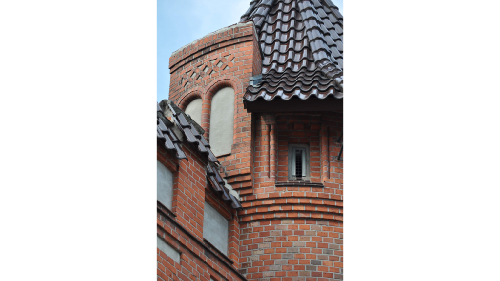 Die Spitze eines der beider Türme des Borsigtors mit Spitzdach und Fensterblenden