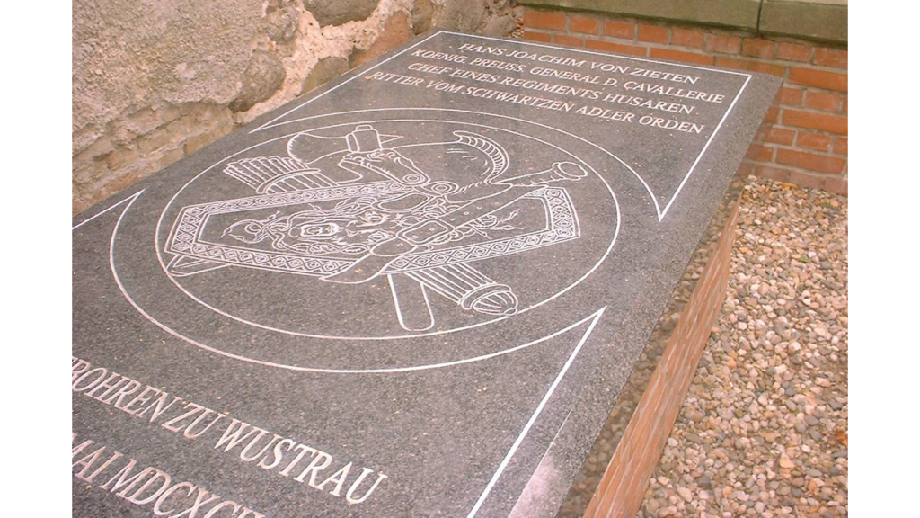Eine steinerne Grabplatte, auf der von Zieten gedacht wird. Ein Wappen ist abgebildet