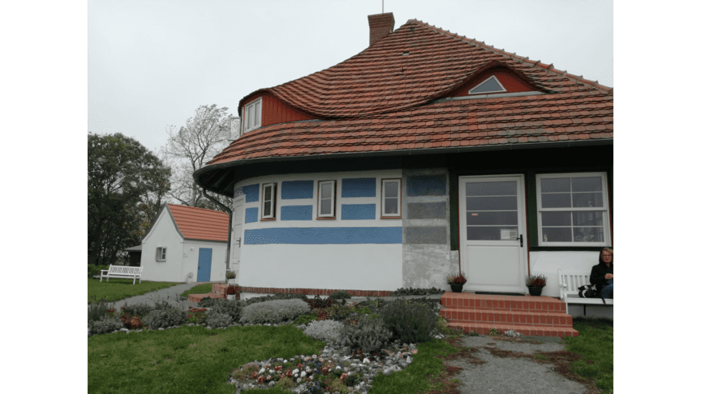 Ein kleines, rundes Haus mit weißer Wand und blauen Streifen