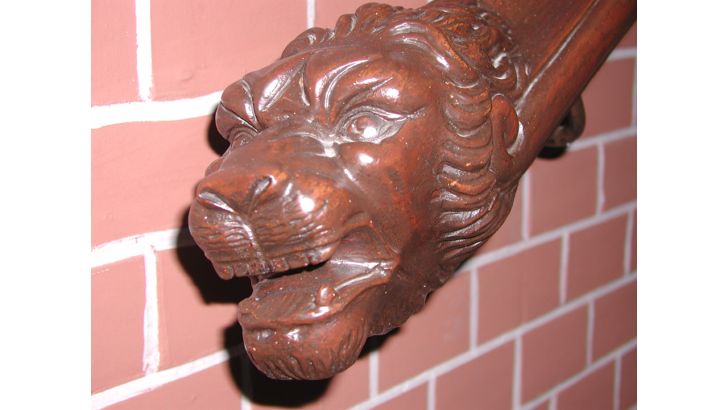 Der aus Holz geschnitzte Löwenkopf am Anfang des Treppengeländers