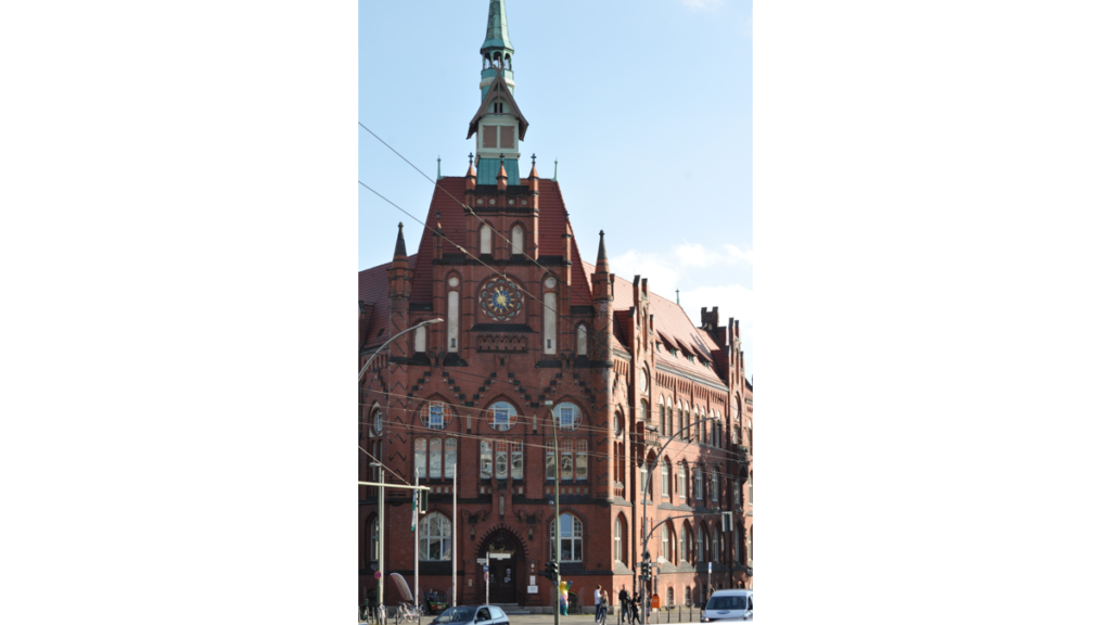 Die Vorderseite des Lichtenberger Rathauses aud rotem Backstein Es läuft nach oben spitz zu und besitzt ganz oben ein Türmchen