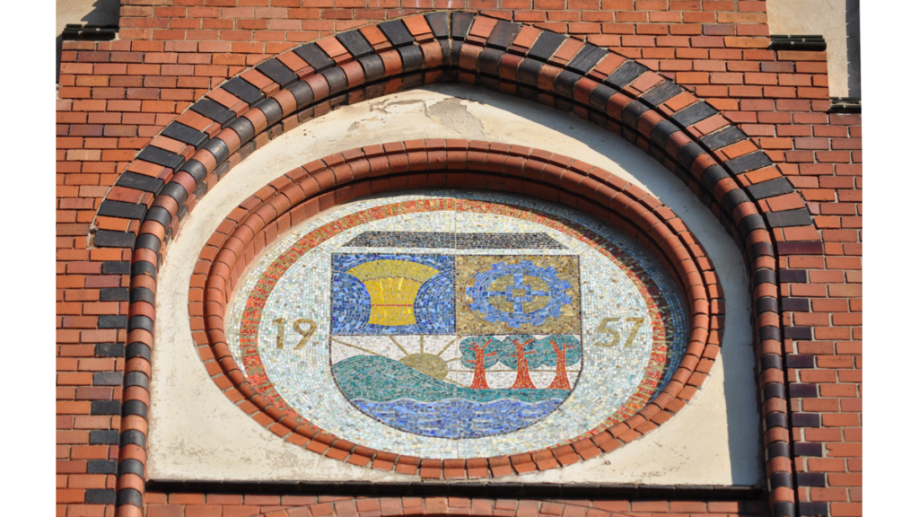 Ein in der Wand eingelassenes Medaillon mit dem Lichtenberger Wappen, nämlich ein Sonnenaufgang mit drei Bäumen, Kornähren und ein Kreuz, an der Fassade des Rathauses Lichtenberg