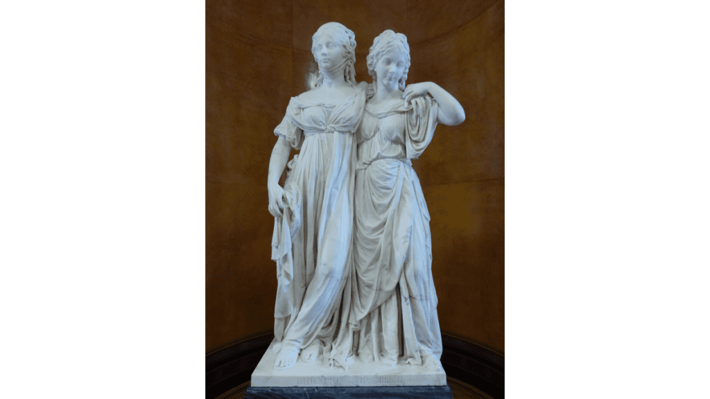 Eine Marmorskulptur zweier Frauen, die die Prinzessinnengruppe genannt wird. Beide sind in klassischen Gewändern gekleidet und haben die Arme umeinander gelegt.