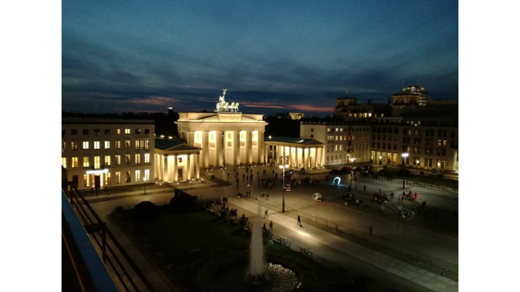 Das erleuchtete Brandenburger Tor samt Vorplatz vor einem Abendhimmel
