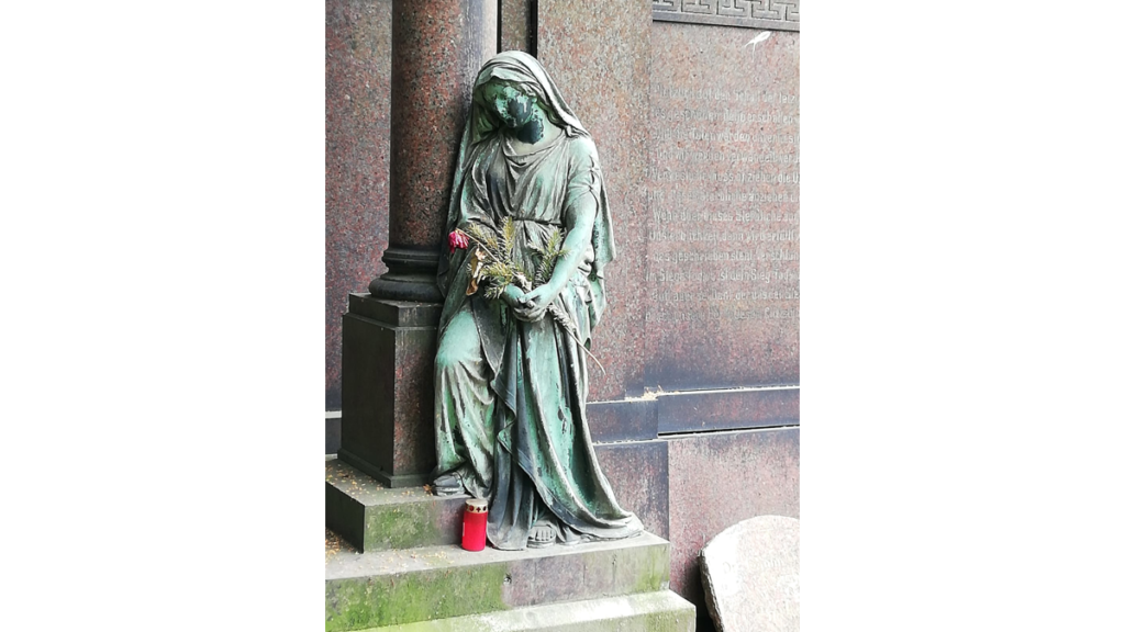 Die Statue einer trauernden Frau auf einem Berliner Friedhof