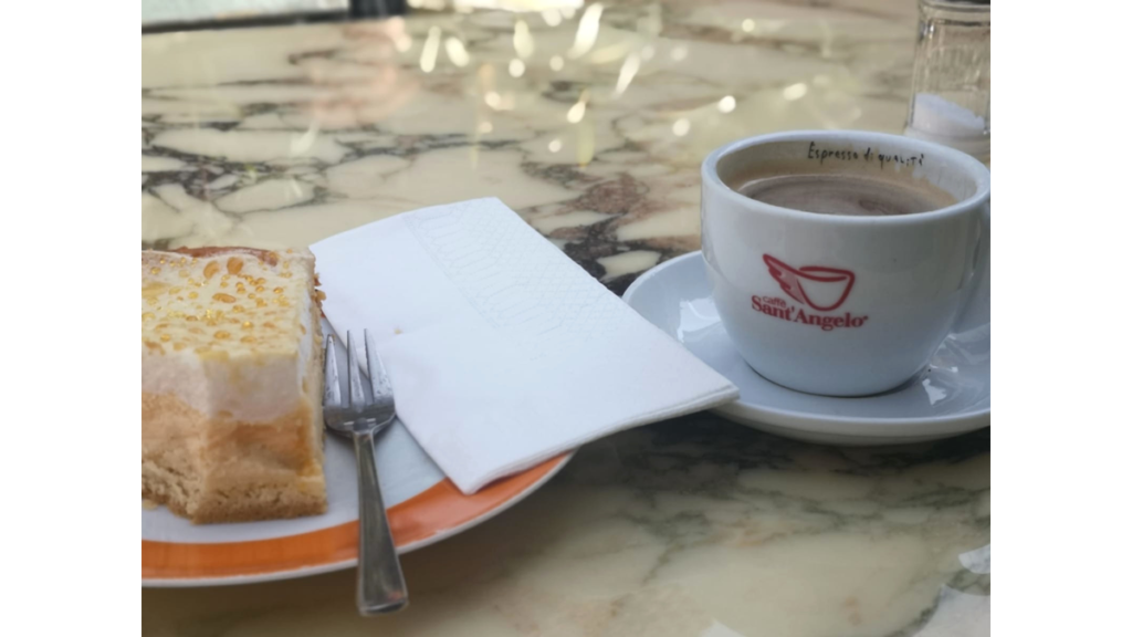 Eine Tasse mit Espresso und ein Stück Kuchen auf einem Tisch