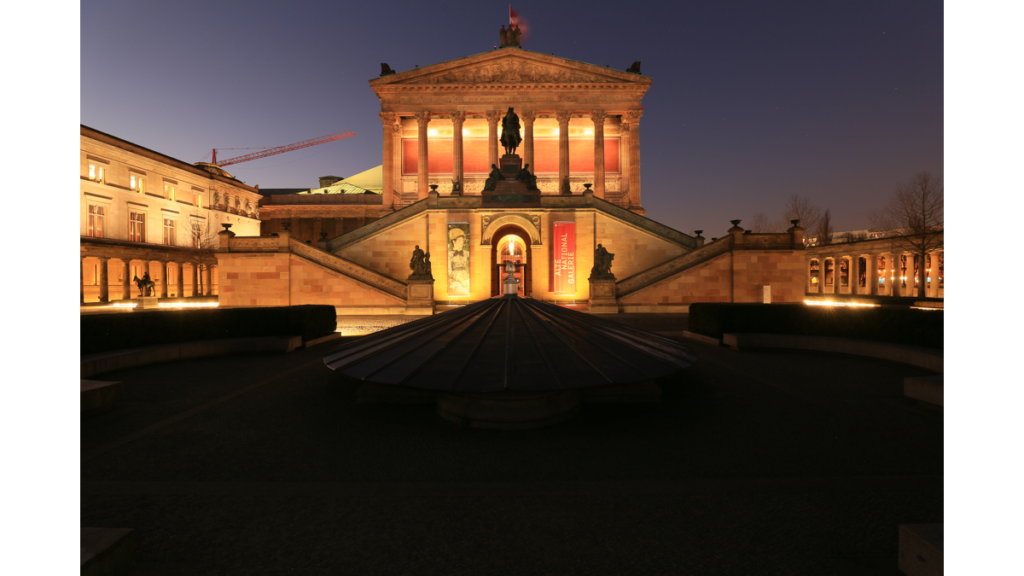 Die erleuchtete Alte Nationalgalerie vom Hof aus gesehen bei Nacht