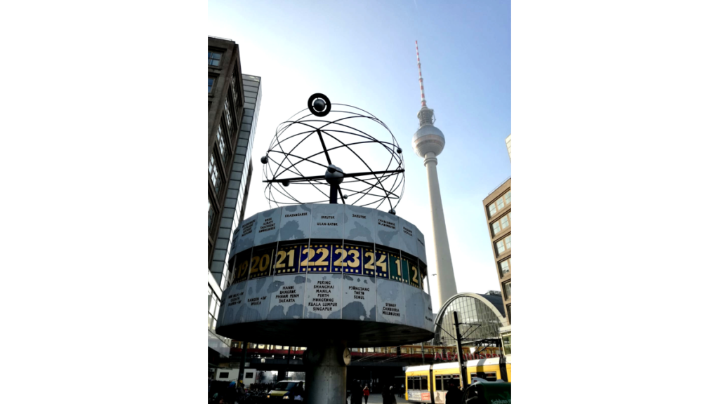 Die Weltzeituhr neben dem Berliner Fernsehturm ist rund und zeigt die 24 Zeitzonen der Erde , darüber befindet sich ein Modell des Sonnensystems