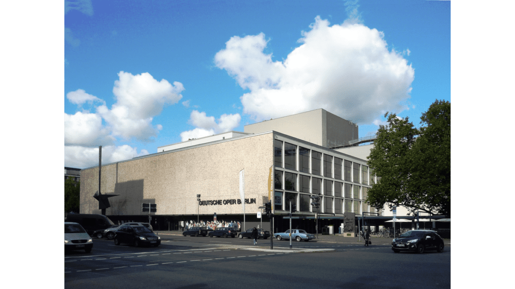 Der kastenförmige Bau der Deutschen Oper in Berlin. An der Seite des Gebäudes ist der Namenszug angegeben