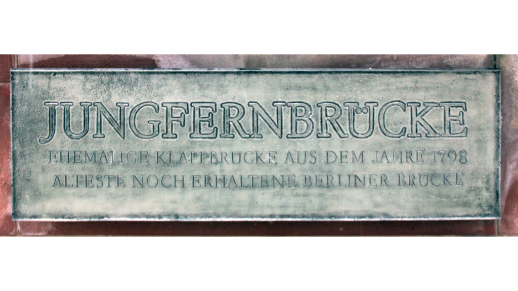 Eine Gedenktafel an die Jungfernbrücke an der Unterwasserstrasse 10, auf dem steht: "Jungfernbrücke. Ehemalige Klappbrücke aus dem Jahre 1798. Älteste noch erhaltene Berliner Brücke."
