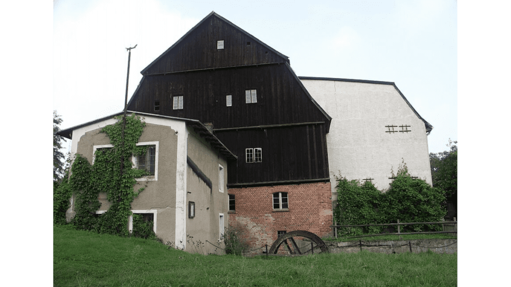 Die Klostermühle Boitzenberg in der Uckermark mit einem Backsteinfundament und dem Wasserrad im Vordergrund