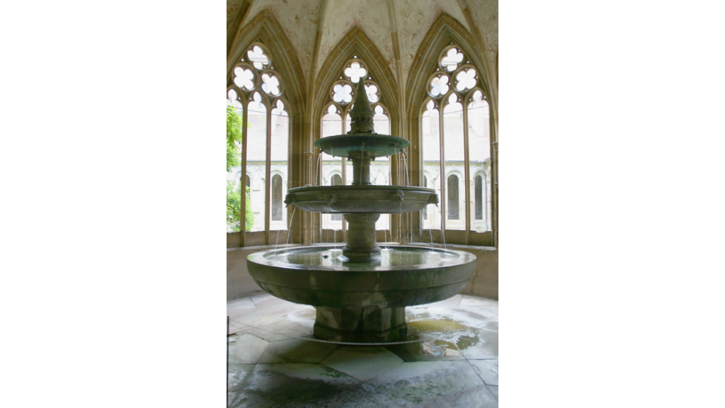 Ein steinerner Brunnen mit drei Terrassen im Inneren des Brunnenhauses im Kloster Maulbronn