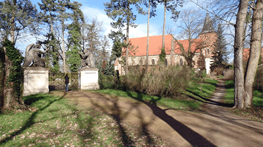 Das Engelstor am Schlosspark Plaue mit der nebenan gelegenen Pfarrkirche