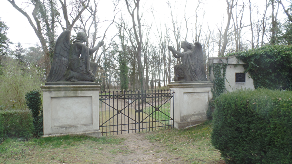 Zwei vom Bildhauer Möller angefertigte Engelsfiguren umrahmen das zweiflügelige Engelstor