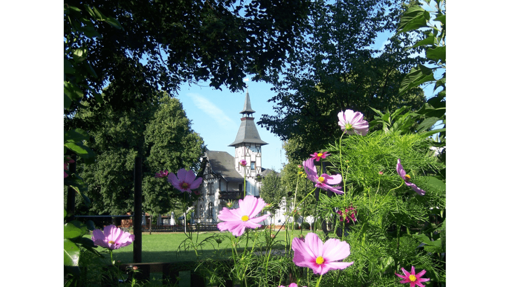 Das 1896 erbaute Vereinshaus des ersten Schrebergartens ist heute Museum und Gasthaus. Es ist hier inmitten von bunten Blumen und Bäumen zu sehen.