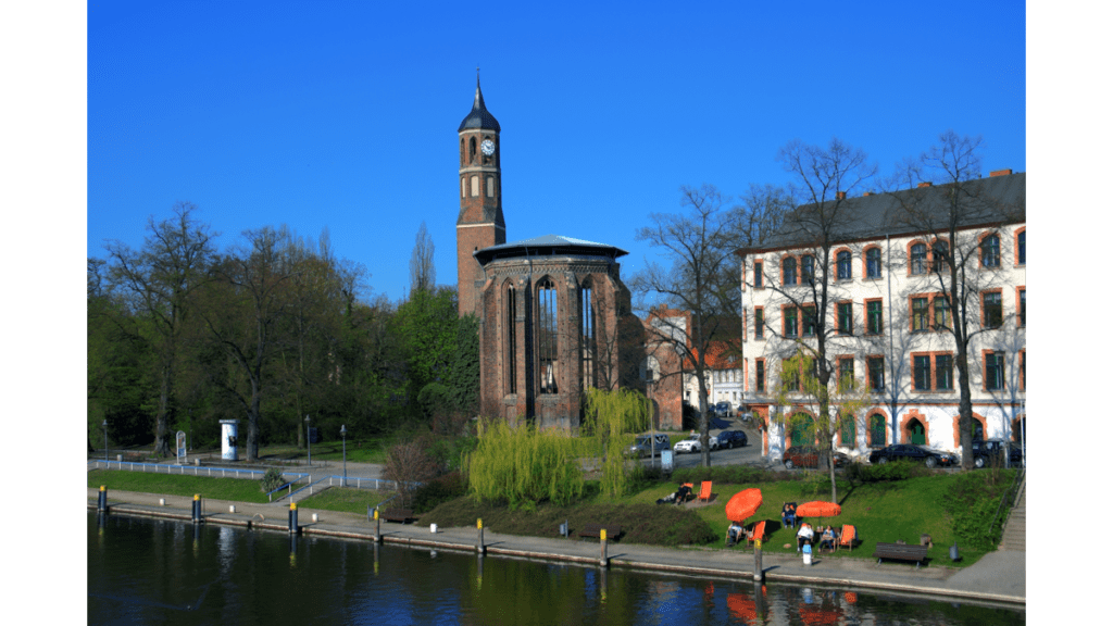 Die Sankt Johanniskirche in Brandenburg. Im Vordergrund fließt die Havel.