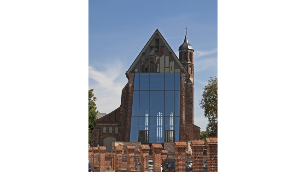 Die durch eine moderne Glasfassade geschlossene Westfassade der Sankt Johanniskirche