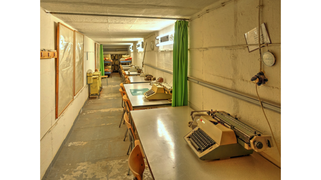 Arbeitsplätze im Stasi-Bunker mit an der Wand entlang laufenden Schreibtischen mit elektrischen Schreibmaschinen