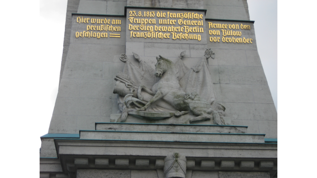 Die goldene Inschrift am Gedenkturm Großbeeren. Dort steht: "Hier wurde am 23.8.1813 die französische Armee von den preußischen Truppen unter General von Bülow geschlagen. Der Sieg bewahrte Berlin vor drohender französischer Besetzung."