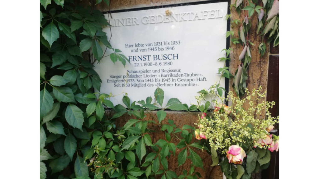 Die weiße Gedenktafel aus Porzellan in der Künstlerkolonie erinnert an das Schicksal des Schauspielers und Regisseurs Ernst Busch