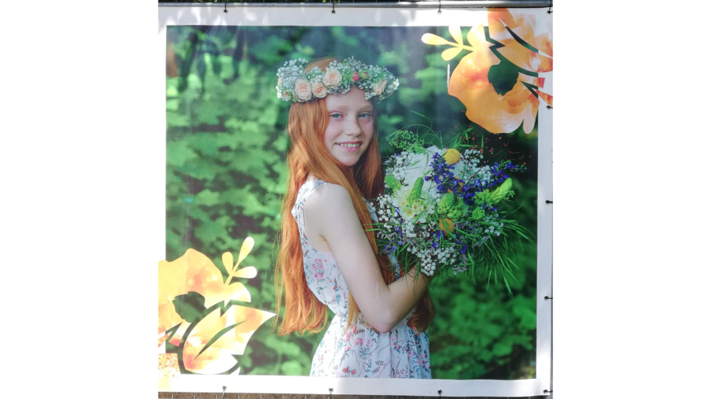 Das Werbeplakat für die Landesgartenschau in Torgau mit einem jungen Mädchen mit Blumenstrauß