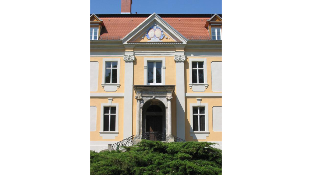 Über dem Balkon sind zwei Kartuschen im dreieckigen Giebelfeld angebracht worden, die das Wappen der Familie von Rochow abbilden.