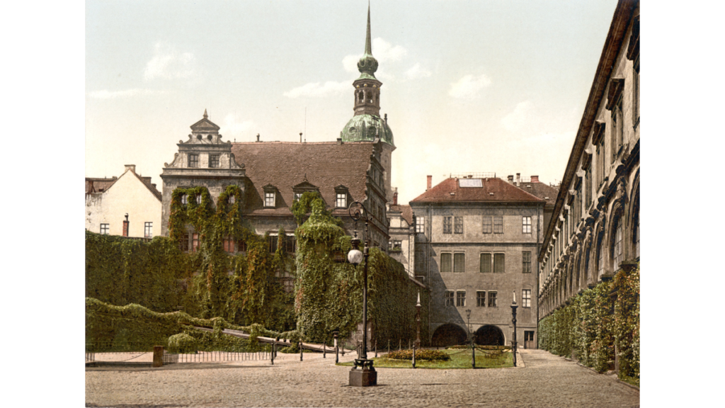 Historische Abbildung vom Stallhof in Dresden aus dem Jahr 1900. Auf der rechten Seite die Arkaden, links im Bild das ehemalige Kanzleigebäude. Dahinter der Hausmannsturm des Residenzschlosses.