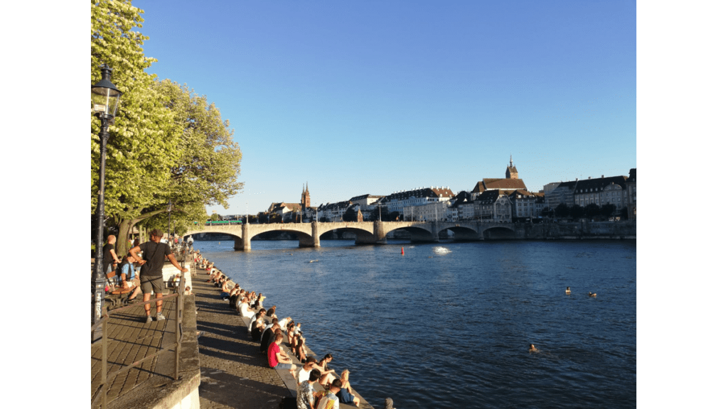 Die Mittlere Rheinbrücke vor der Altstadt von Basel mit wagemutigen Flussschwimmern
