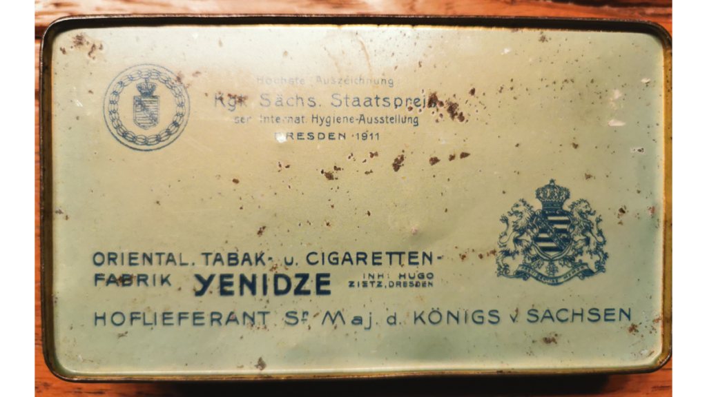 Eine Tabakdose, die die Zigarettenfabrik Yenidze als Hoflieferanten des Königs von Sachsen ausweist.