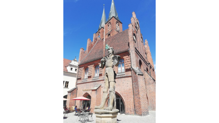 Der Roland auf dem Marktplatz vor dem Rathaus in Stendal, dahinter die Marienkirche.
