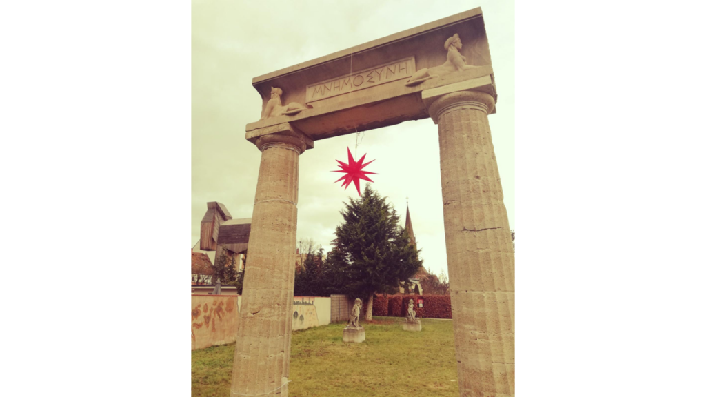 Ein Herrnhuter Stern zwischen klassischen Säulen im Garten des Winckelmann Museums