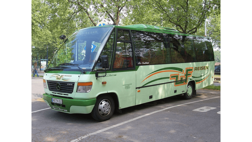 Ein mintgrüner Clubbus auf einem Parkplatz.