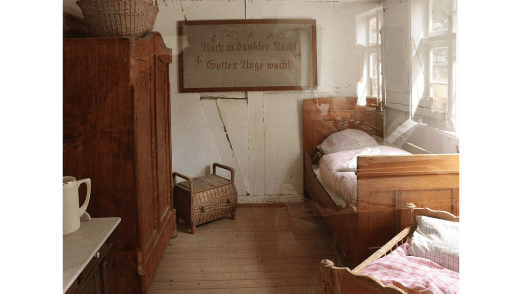 Eine historisch gestaltete Bauernstube im Freilichtmuseum mit Betten, Truhen und Schrank.