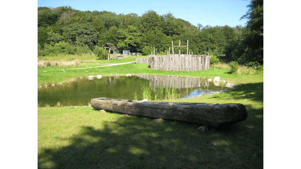 Ein Einbaum, wie er zum Fischen verwendet wurde, vor einem Teich im Steinzeitpark Dithmarschen.