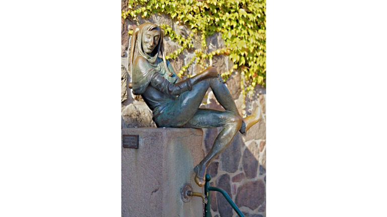Die Figur Till Eulenspiegel sitzt auf einem Brunnen in der Altstadt von Mölln.