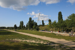 Foto: © Stefan Schaubitzer / comkomm Ein langer Weg, der durch einen Park führt. Im Hintergrund sind Lichtanlagen erkennbar